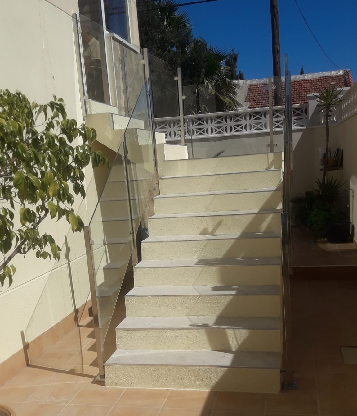 Transparent glass stair railing enhancing garden design in Rojales