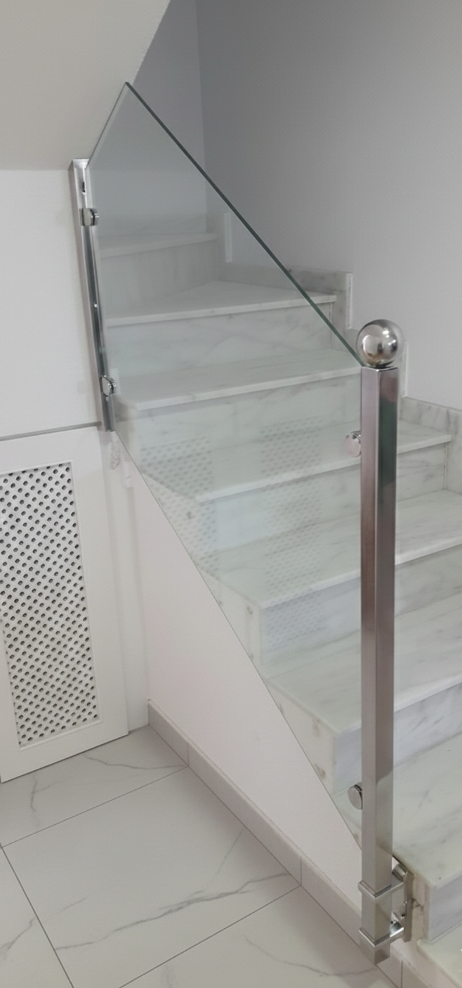Made-to-measure glass balustrade system with stainless steel fittings for luxury interior space.